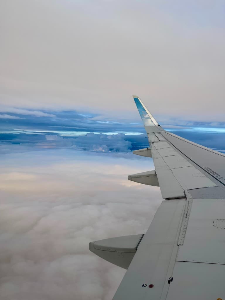 View from an airplane window above the clouds